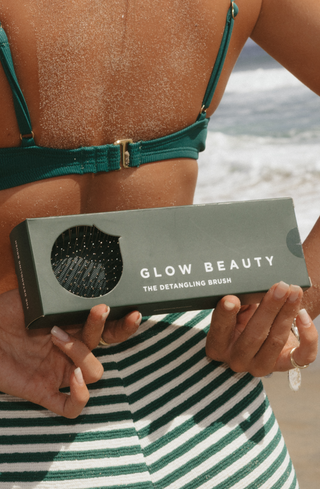 Glow Beauty Detangling Brush in olive green on floral background