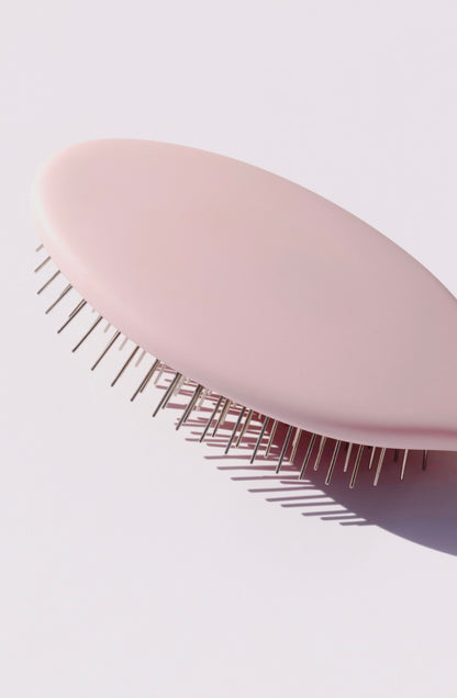 Glow Beauty Detangling Brush in ballerina pink on marble surface